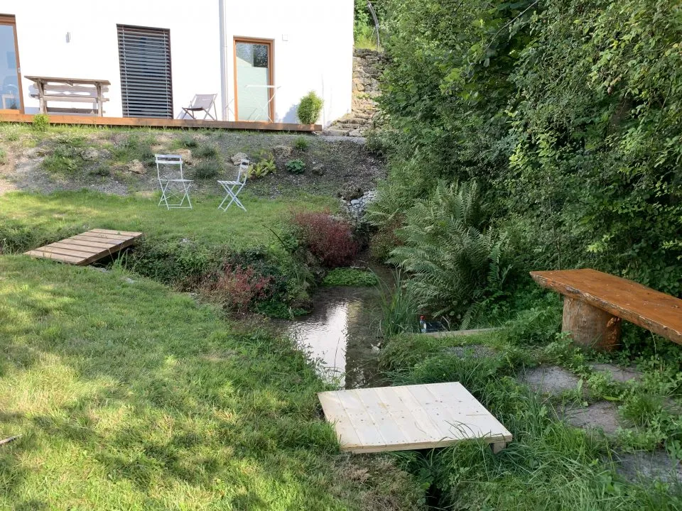 Garten mit Bachlauf, Trittsteinen und Holzbank