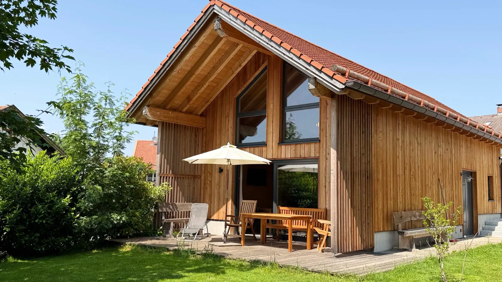 Holzchalet mit Terrasse und Sonnenschirm