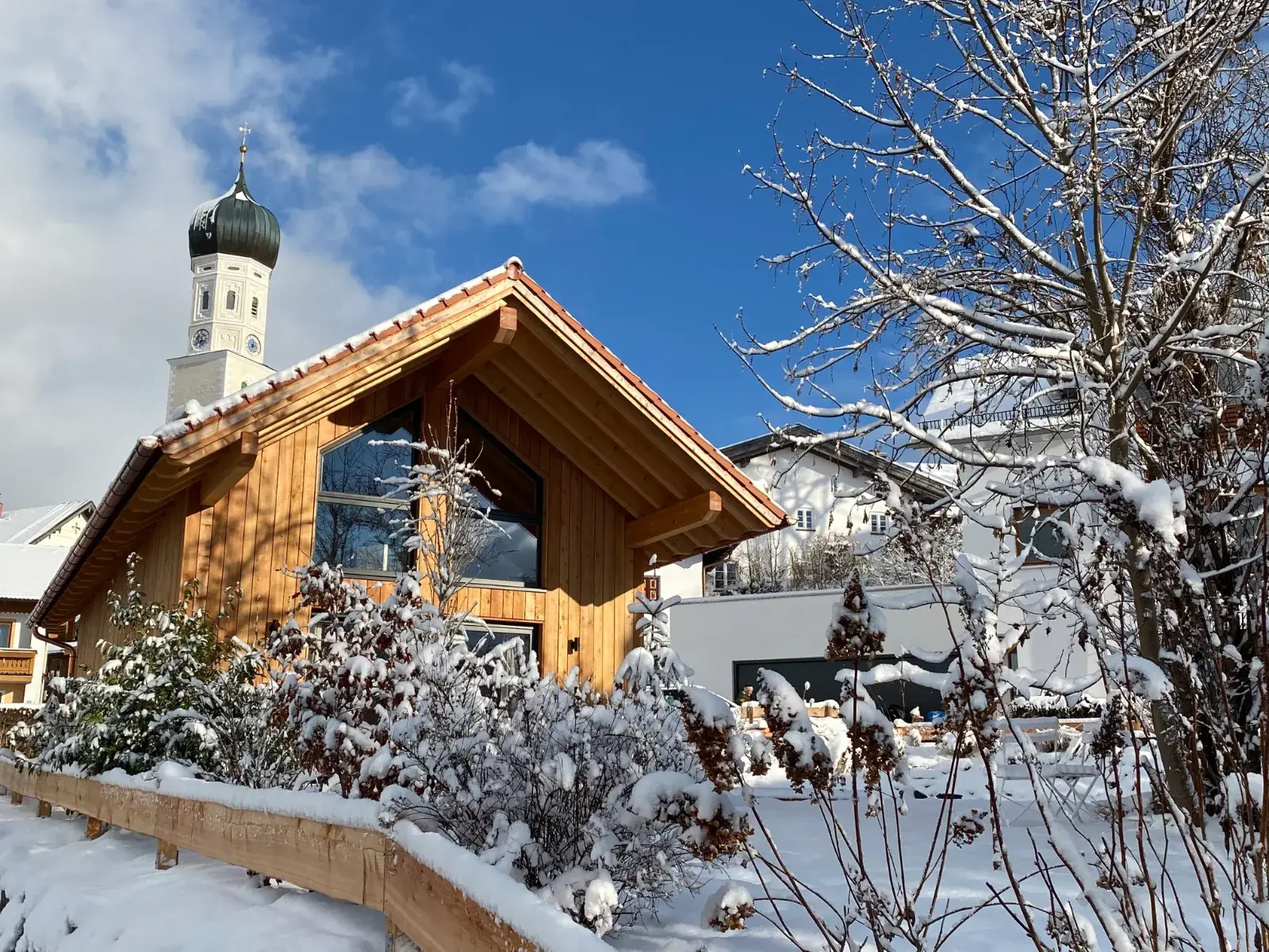 Chalet im Winter mit Kirchturm