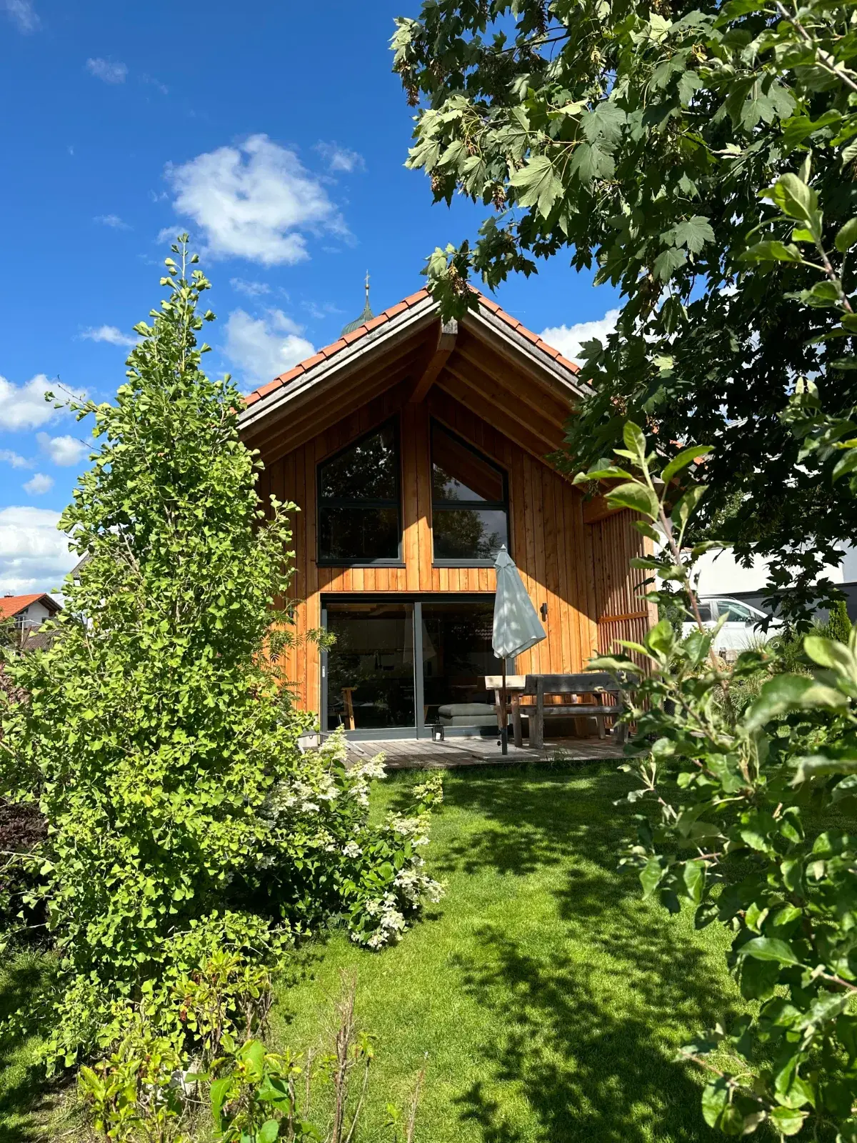 Giebel des Chalets mit Ginkgo, Hortensien und Terrasse