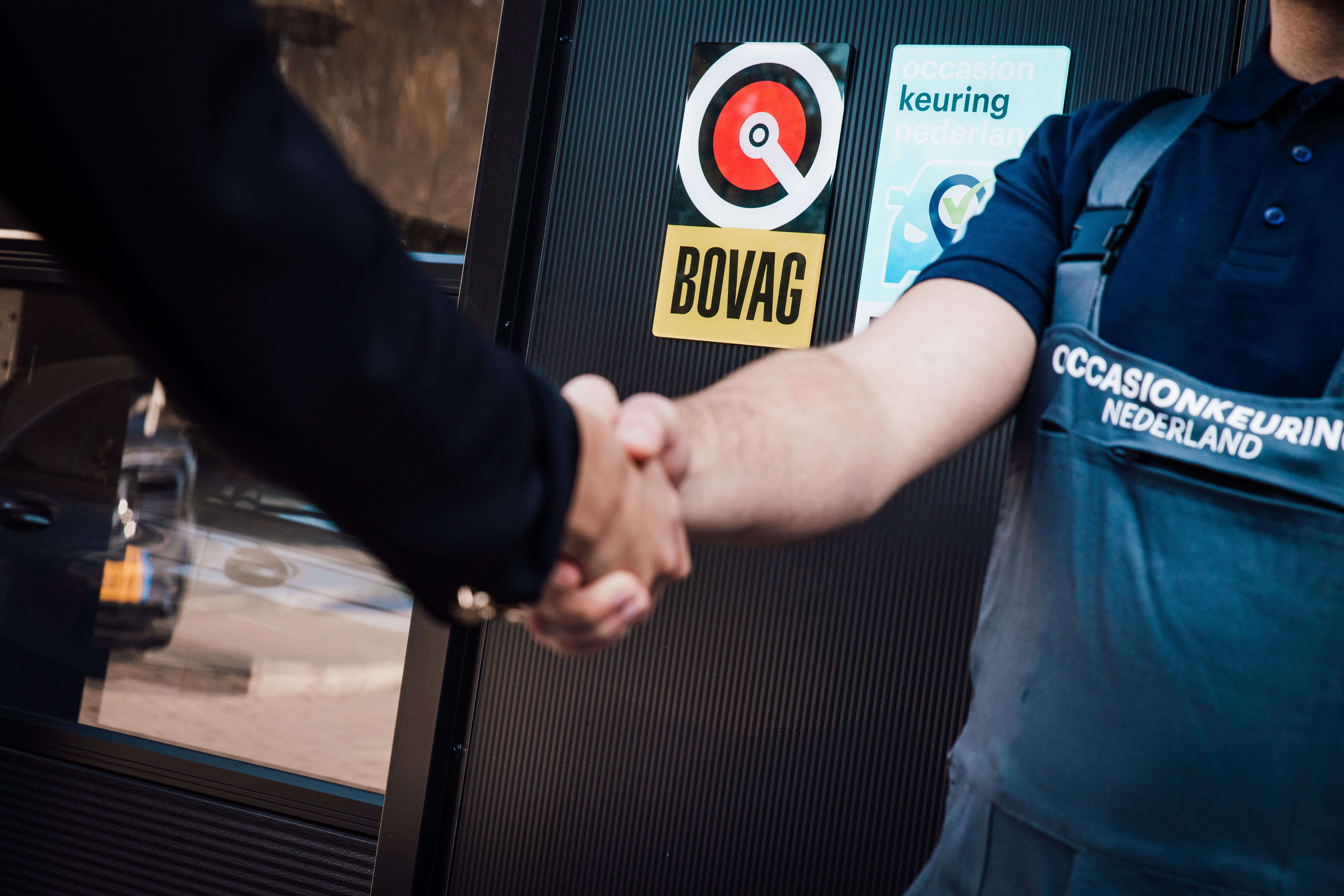 Monteur schud de hand met een klant na een autokeuring