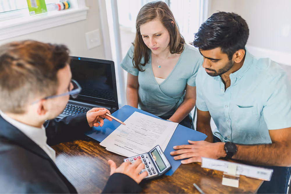 couple being shown form by an advisor with calculator