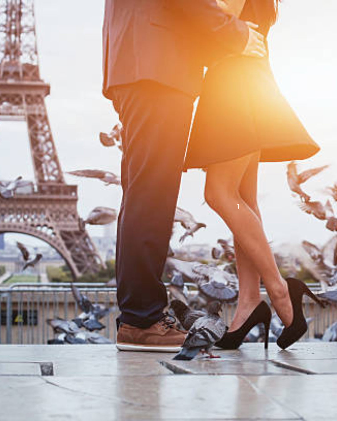 man and woman dressed up in an embrace by the eiffel tower