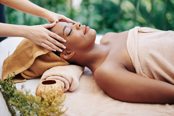 black woman laying down at an outside spa getting a massage