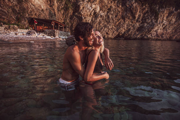 man and woman in the ocean in a loving embrace