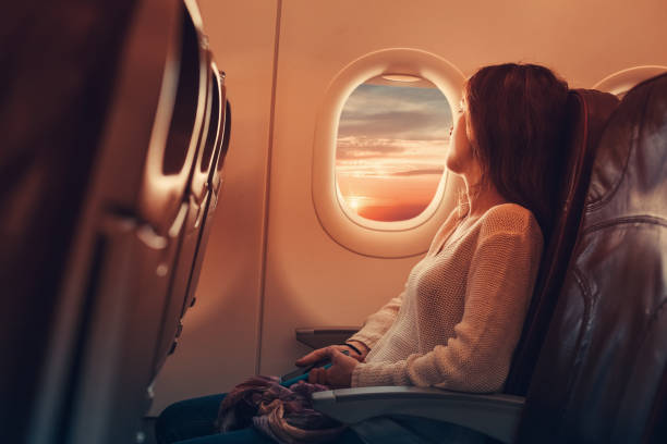 woman on an airplane looking out the window