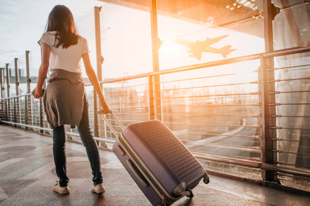 woman at the airport at sunset, pulling her luggage