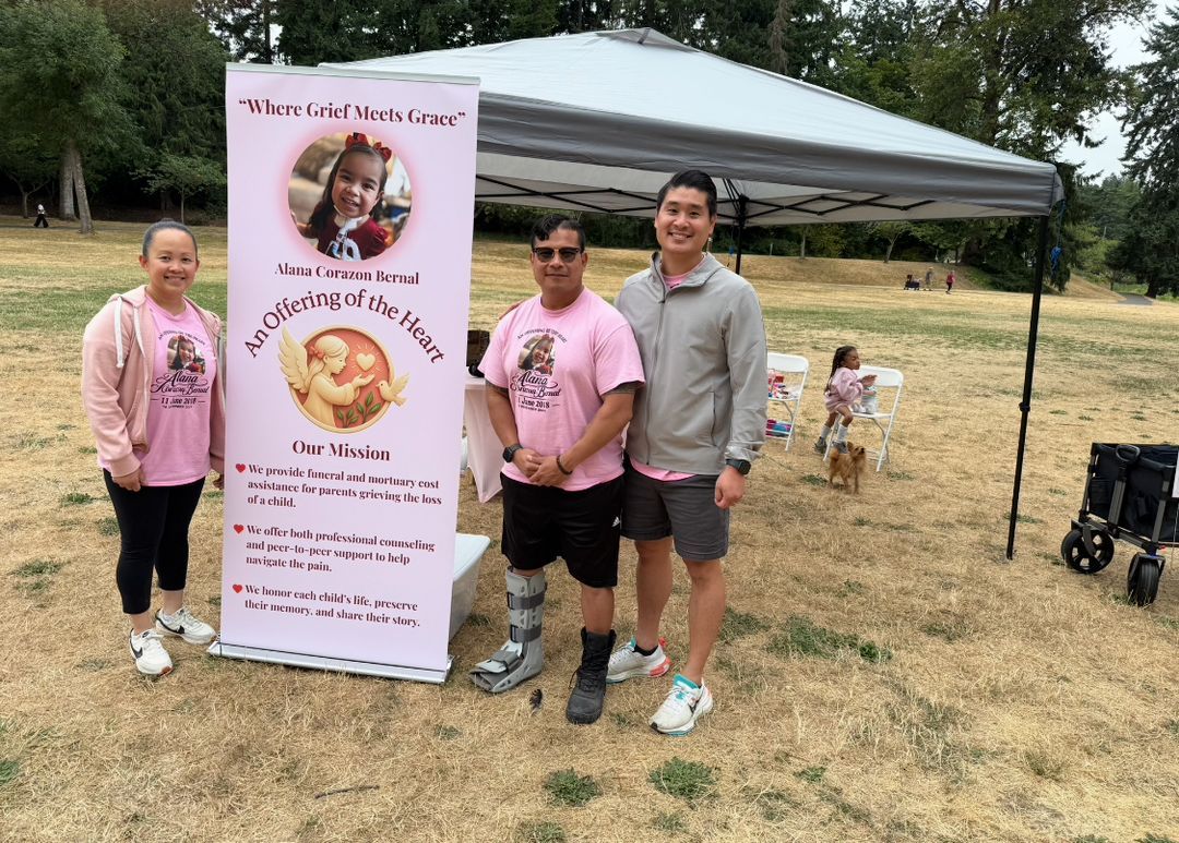 Three people beside the Where Grief Meets Grace banner in the park