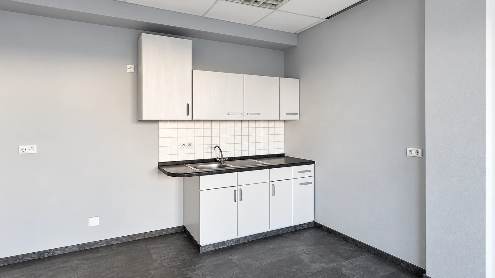 Shared kitchenette at GODU with white cabinets, sink and worktop
