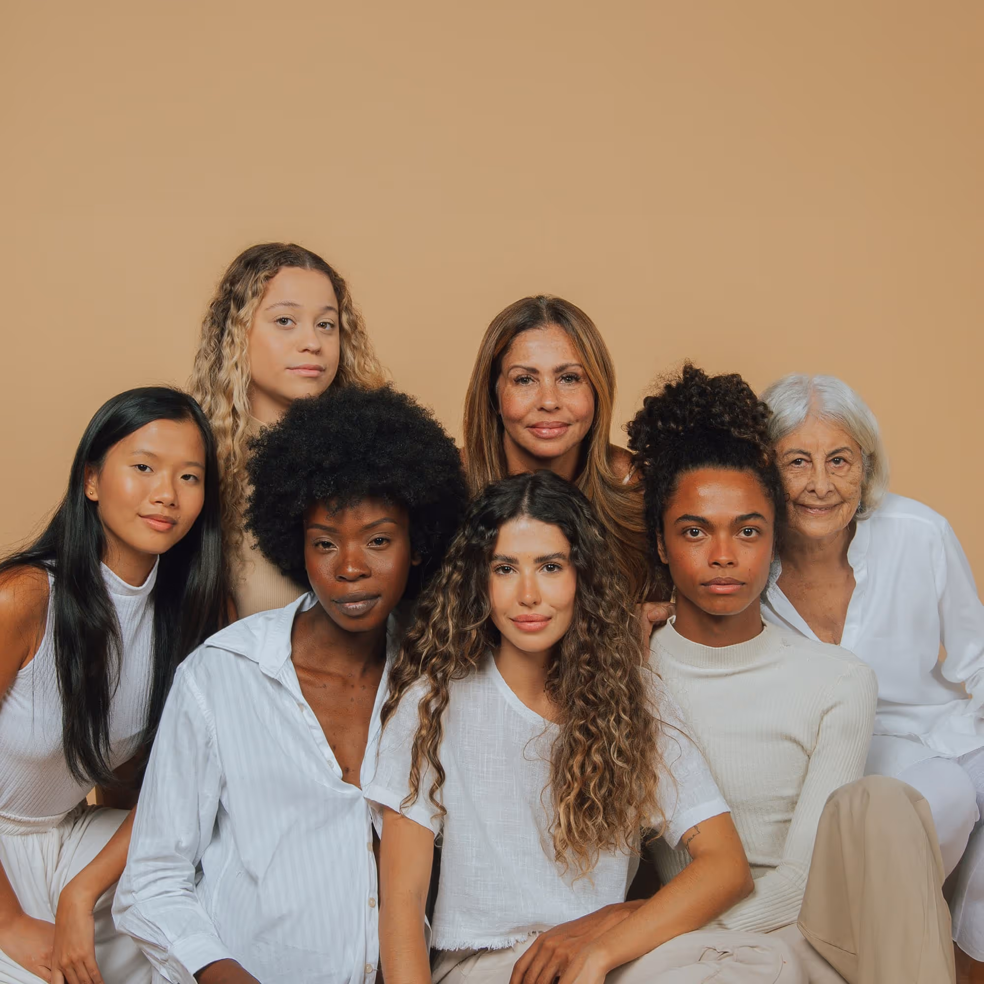 Diverse multigenerational group of women in neutral tones showing community and inclusion across ages and backgrounds