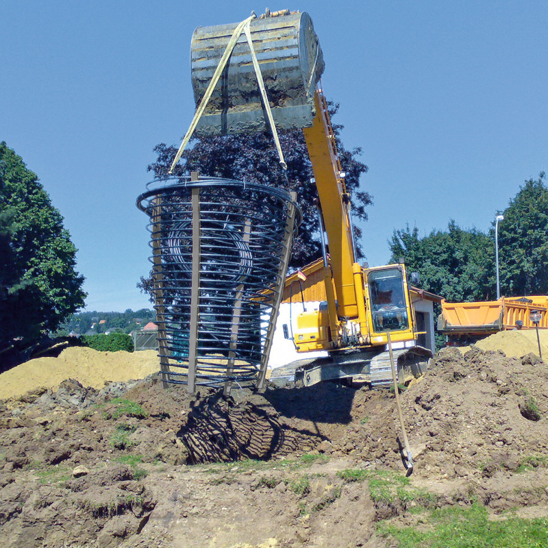 Einbau eines Erdwärmekorbes gehoben durch Bagger