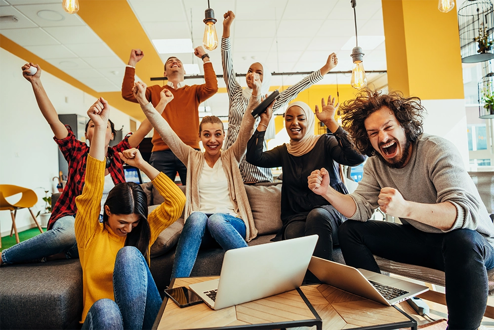 Employees celebrating by cheering and hands in the air