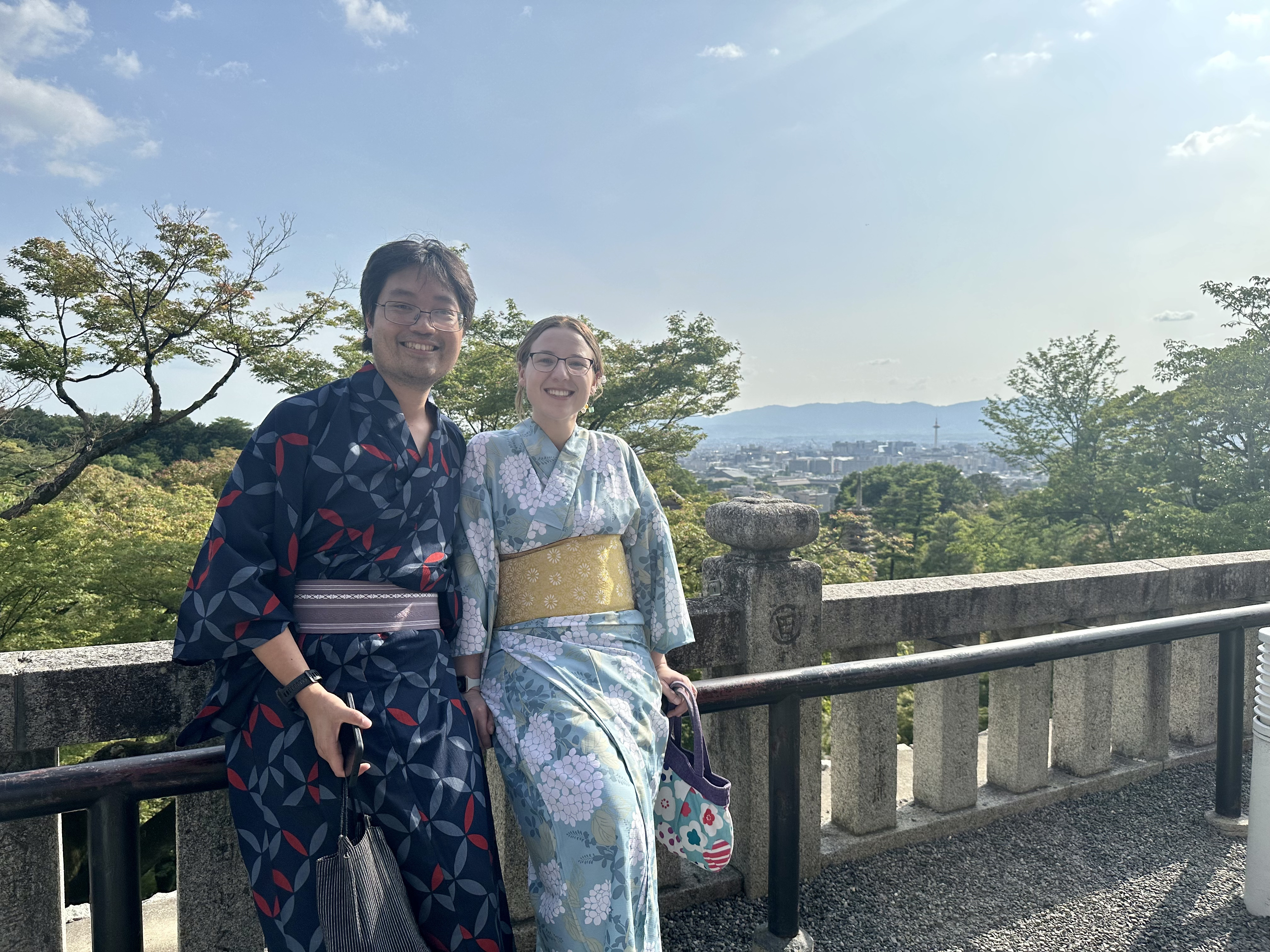 Mari-Alina Timoshchuk and Cassidy Sung in Kyoto Japan overlooking the city on a sunny day in kimonos and yukatas
