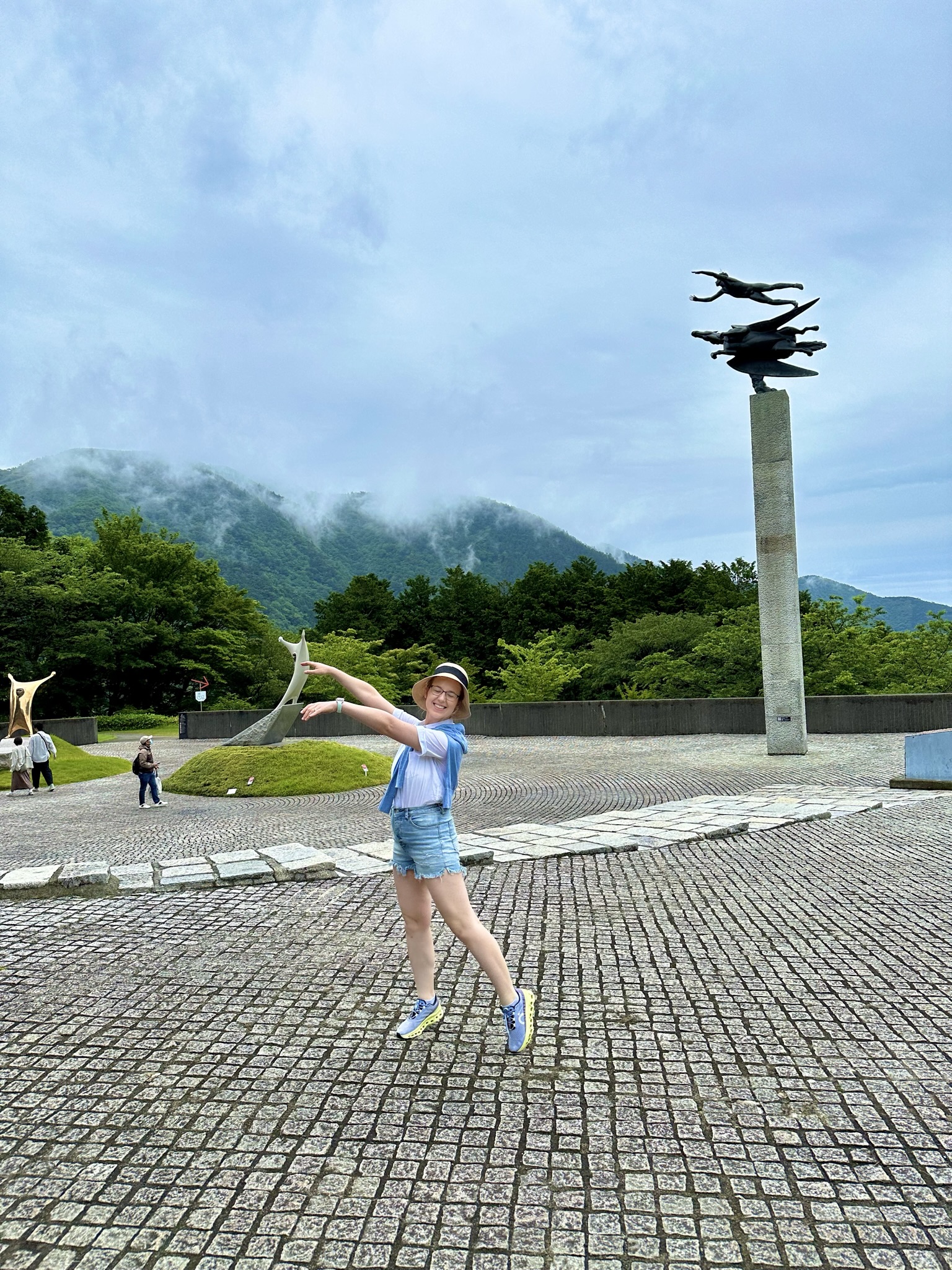 Mari-Alina Timoshchuk posing like a sculpturewith the sculpture behind her 