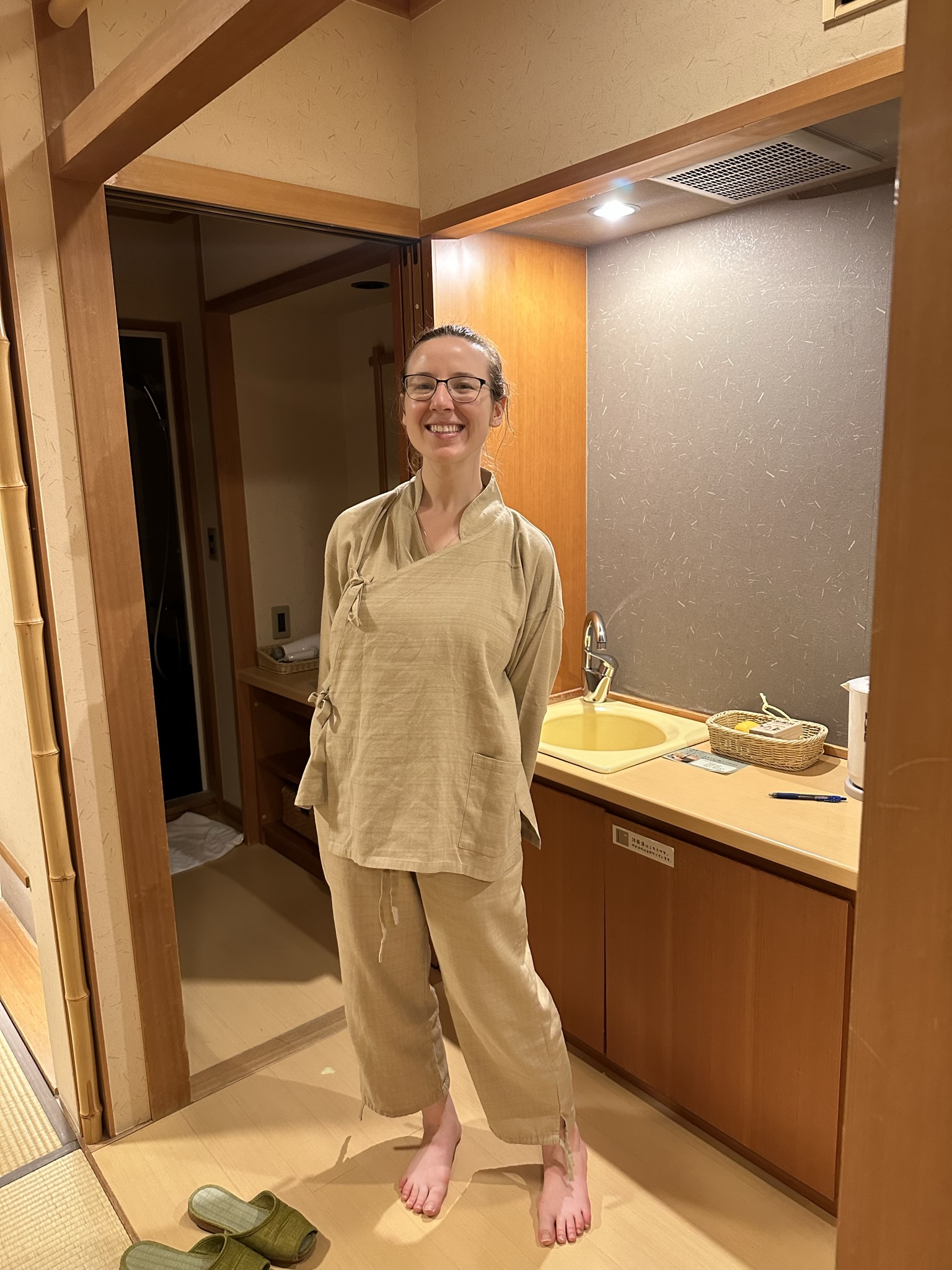 Mari-Alina Timoshchuk in Japanese pajamas in a hotel room smiling. 