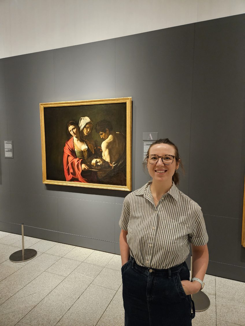 Mari-Alina Timoshchuk in front of a Caravaggio painting in Madrid Spain