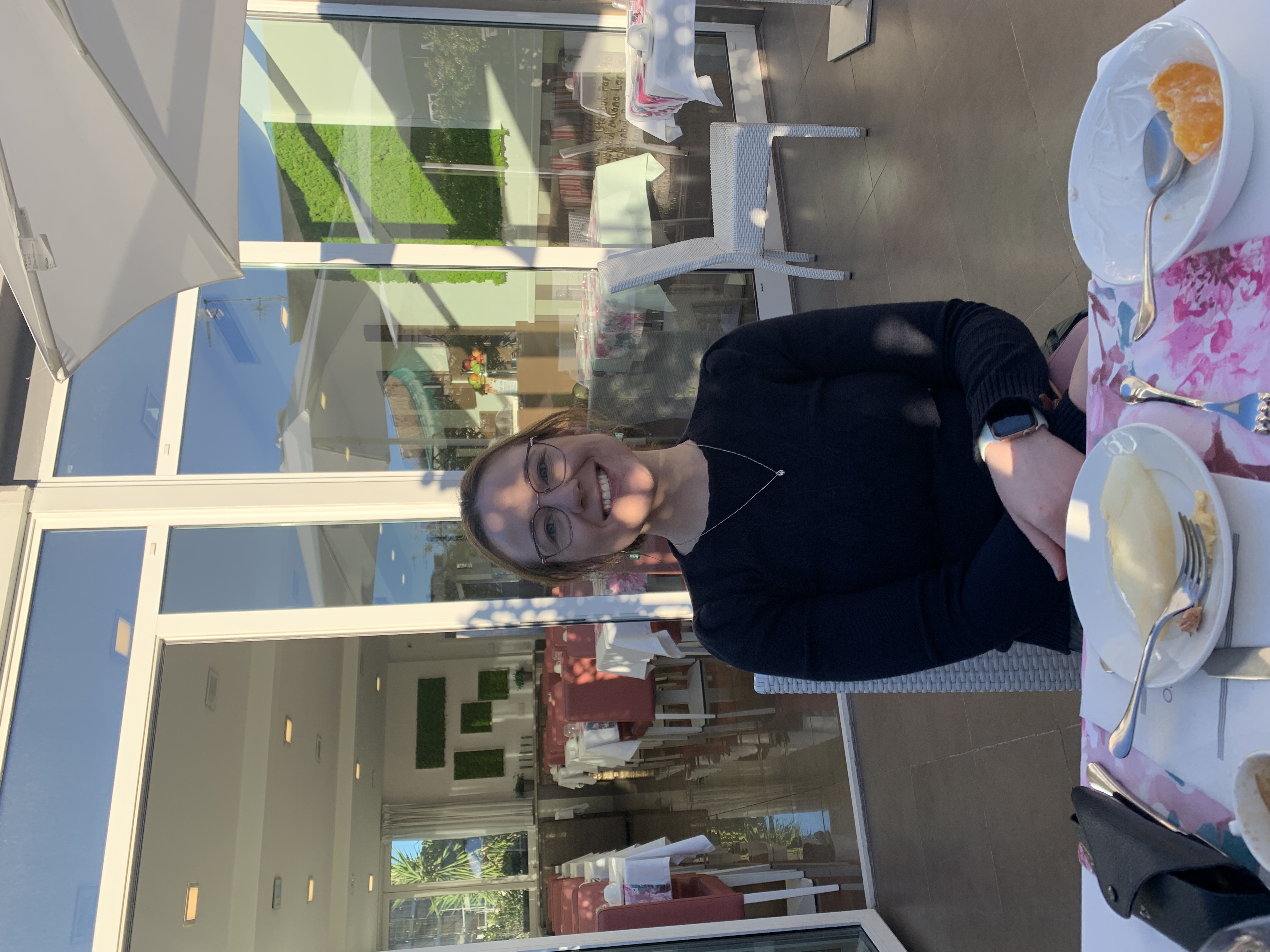 Mari-Alina Timoshchuk at a table in Italy. She is at a hotel having breakfast. 