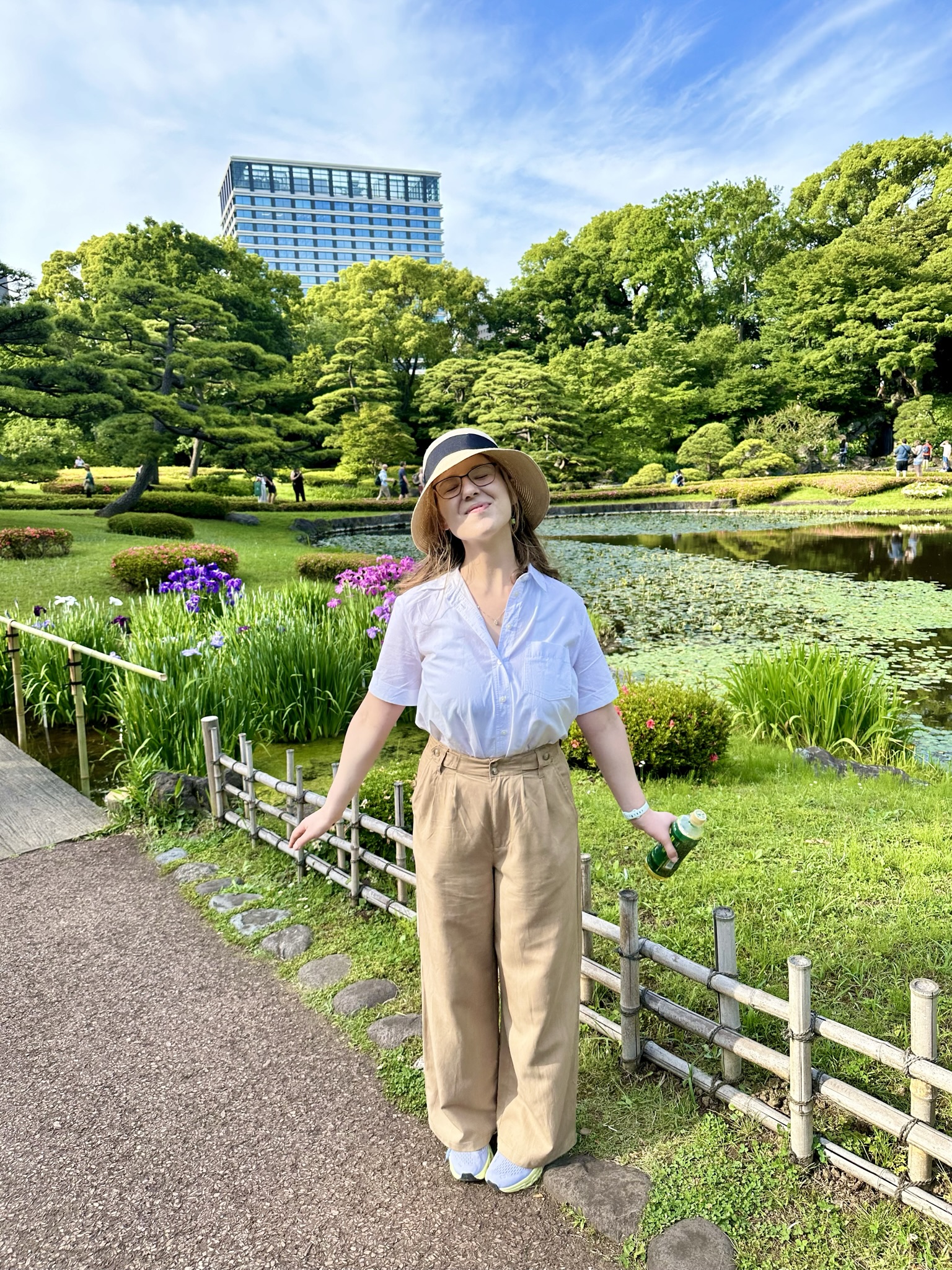 Mari-Alina Timoshchuk at a garden in Tokyo looking at the sky and enjoying the sunshine surrounded by flowers