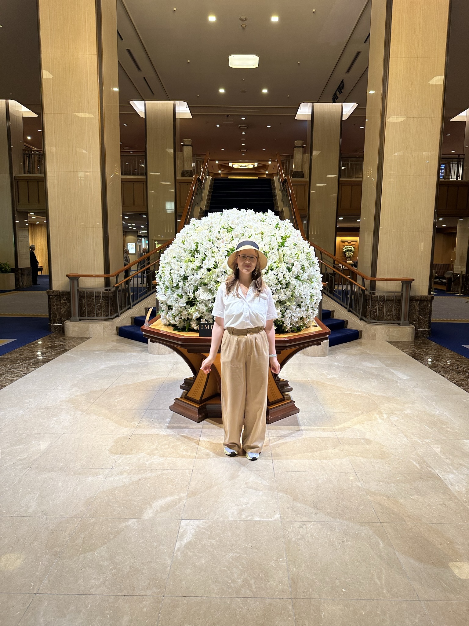 Mari-Alina Timoshchuk at the Imperial Palace Hotel in Tokyo in front of their white roses display