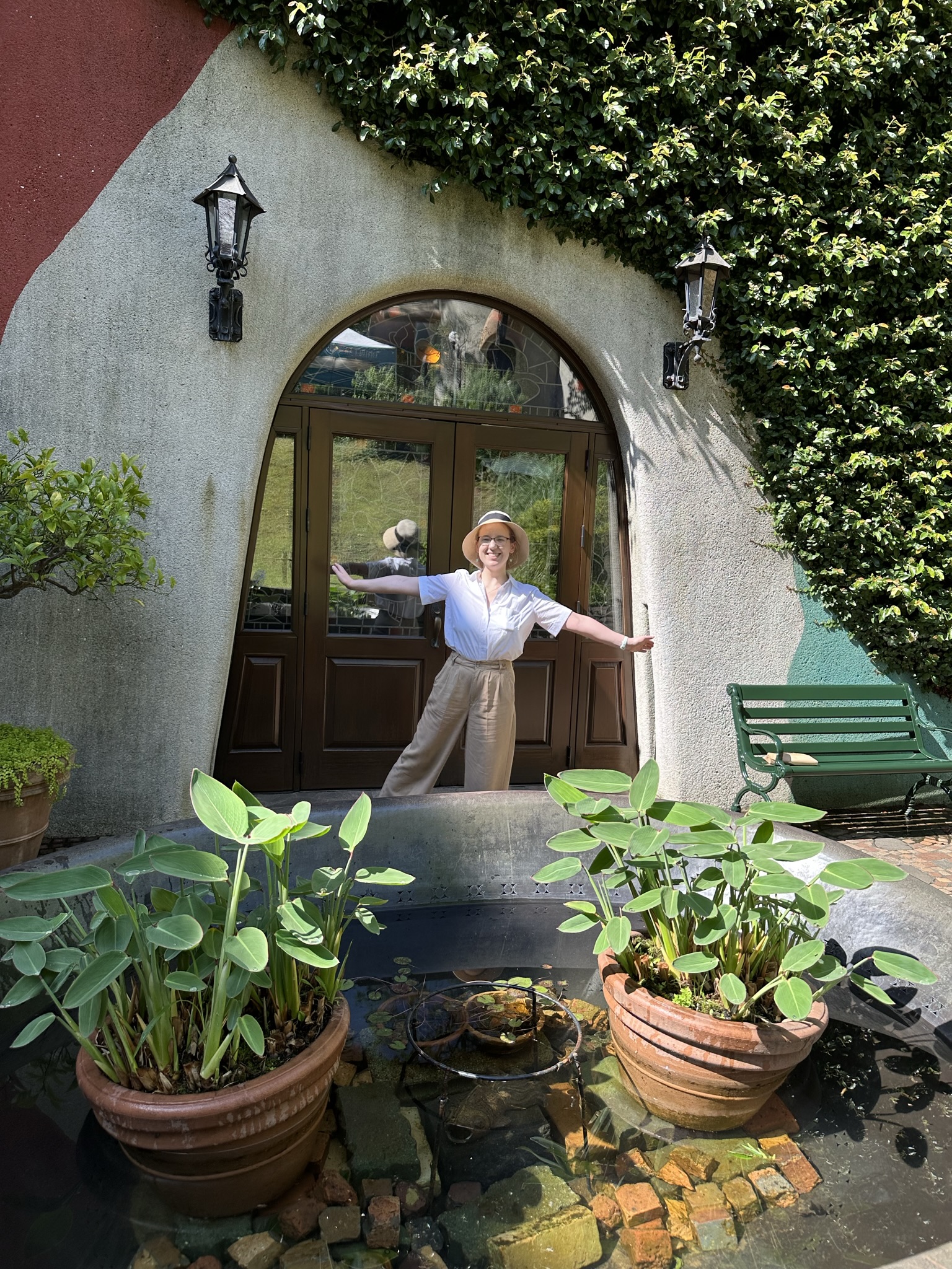 Mari-Alina Timoshchuk at the Studio Ghibli museum posing next to a small door of a cottage