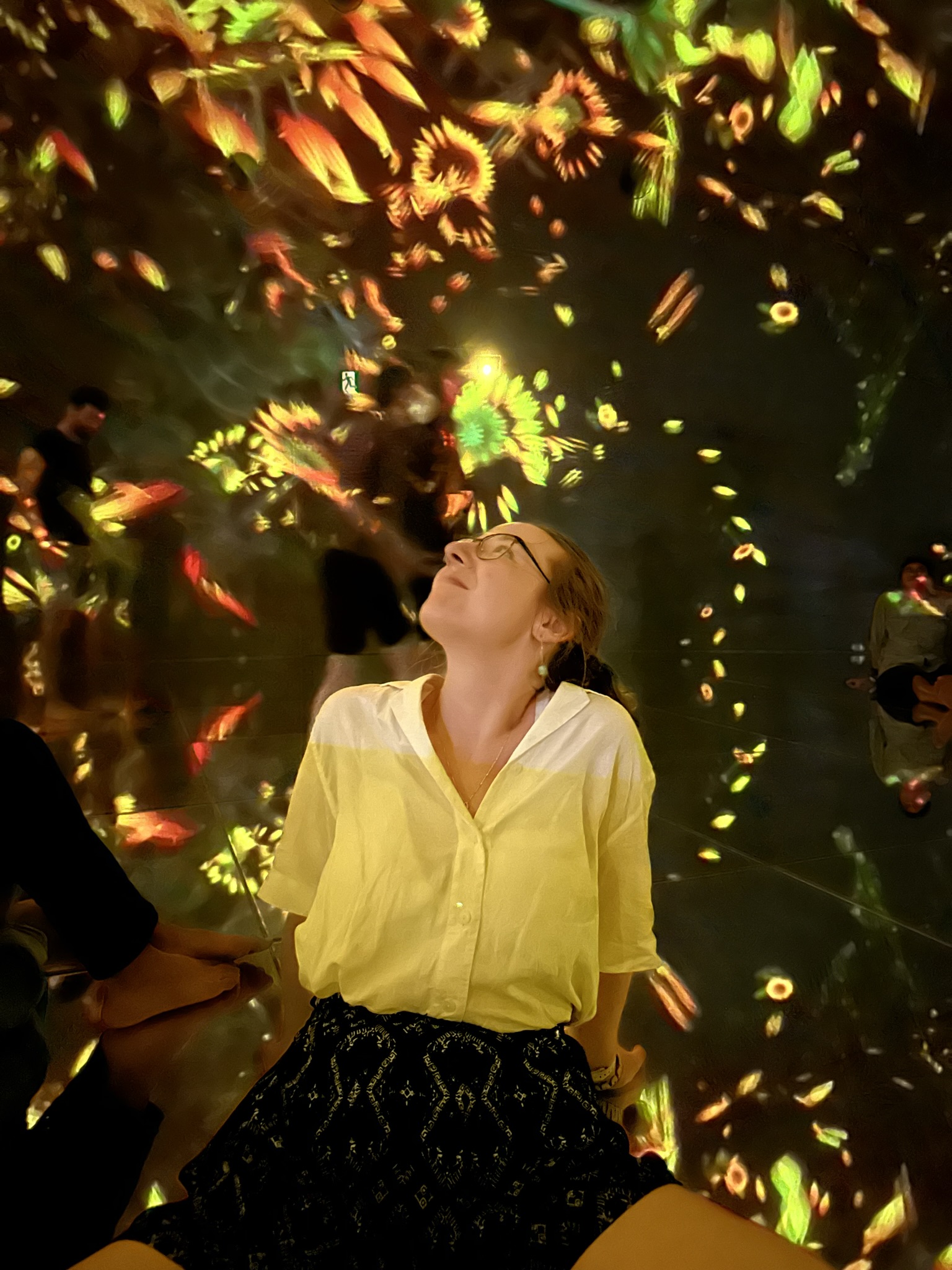 Mari-Alina Timoshchuk at teamLabs Planets in Tokyo with a lot of sunflowers in the background. 