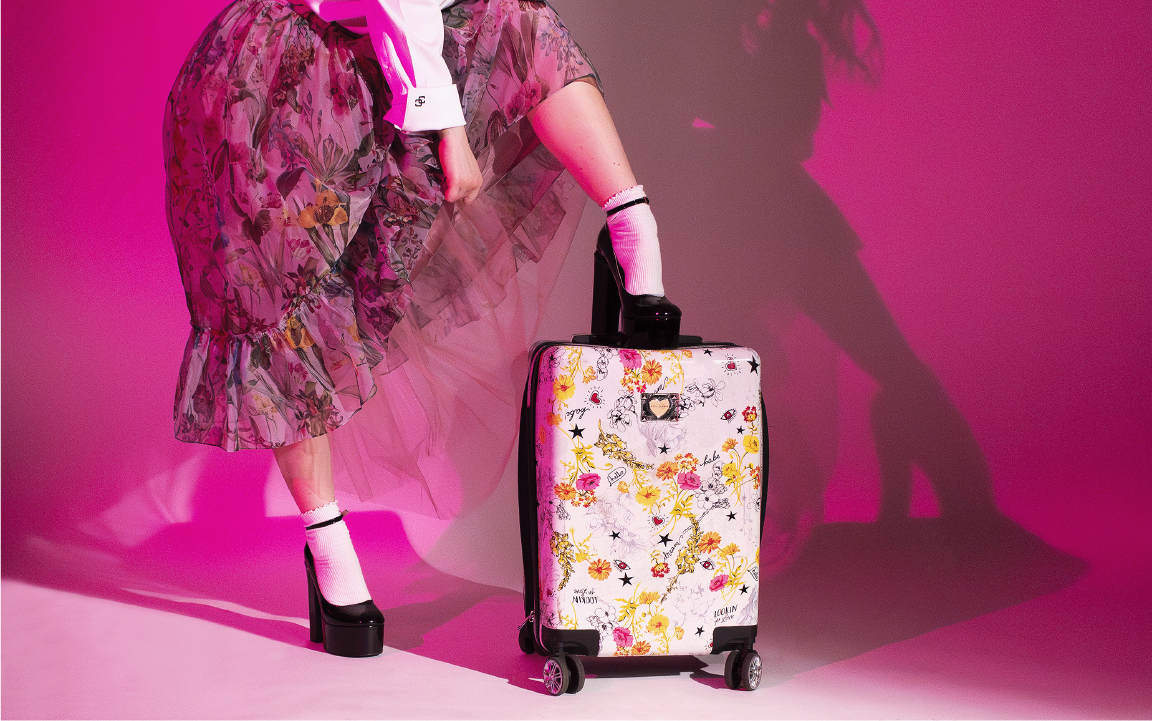 woman stepping on top of carry on suitcase