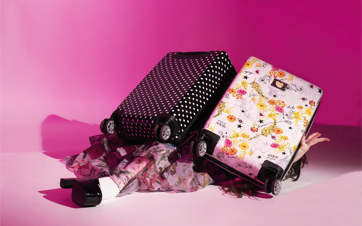 woman positioned under carry on suitcase