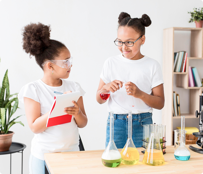 Two young girls conducting a science experiment with beakers and test tubes.