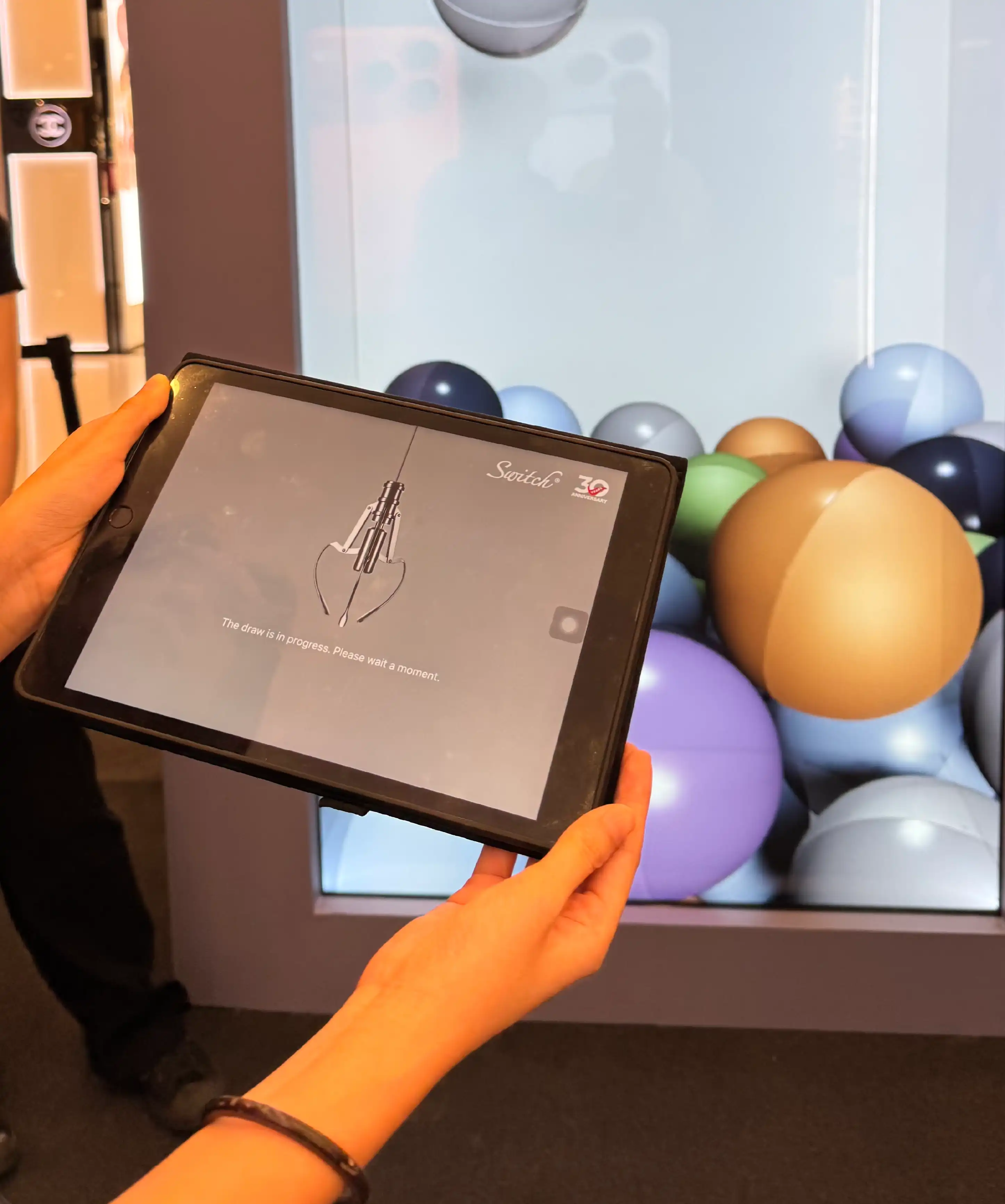 Guests using iPad Pro and touchscreen controls to play digital claw machine at Switch x iPhone 17 launch event Sunway Pyramid Kuala Lumpur Malaysia