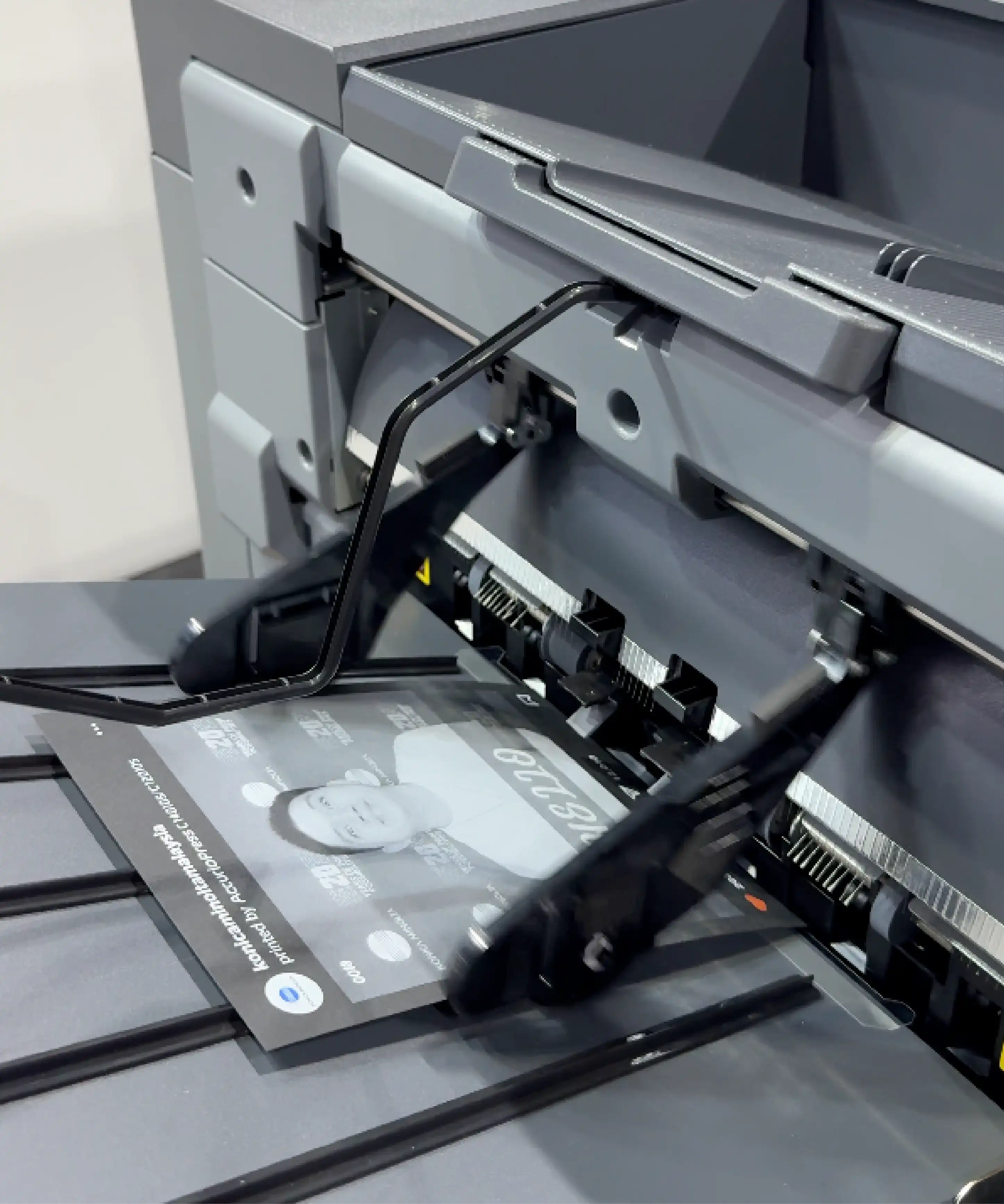 Konica Minolta white-based ink printer producing monochrome photo on black medium