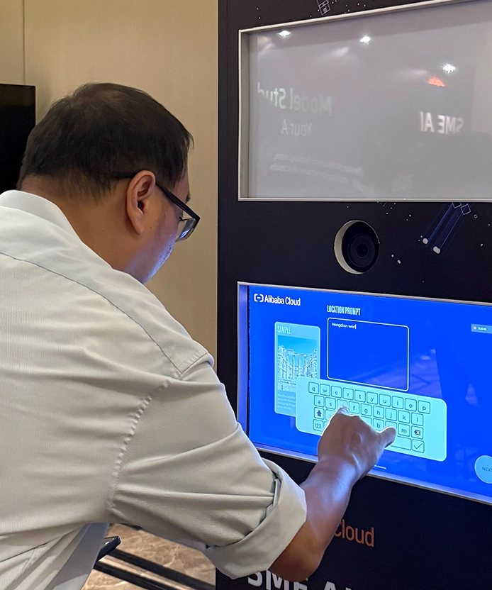Man tapping the touchscreen of the Alibaba Cloud AI photo kiosk.