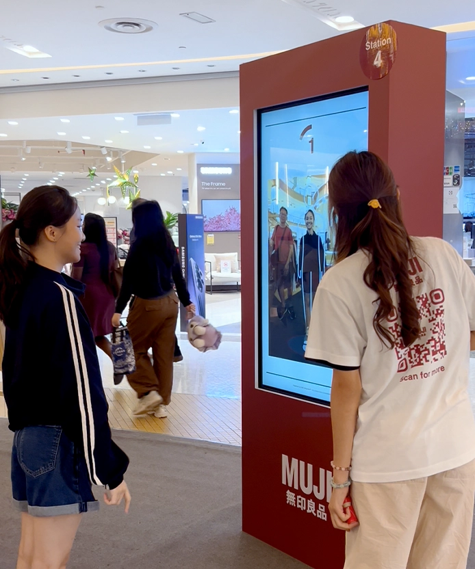 Customers exploring the red MUJI kiosk inside the store.