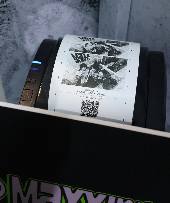 Thermal printer dispensing a black-and-white Maxxin 95 photo receipt with QR code.