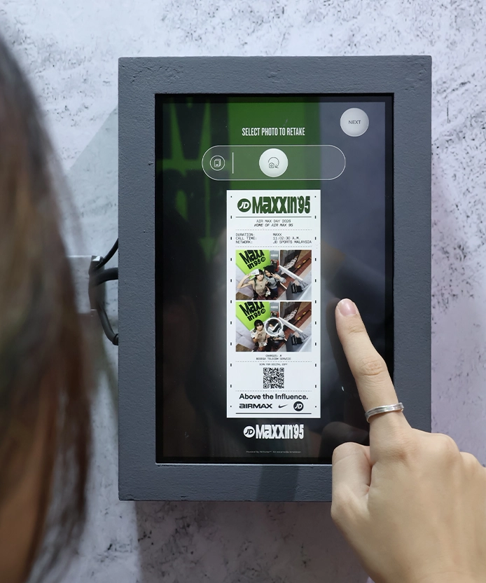 Finger tapping the touchscreen to preview the JD photo strip design.