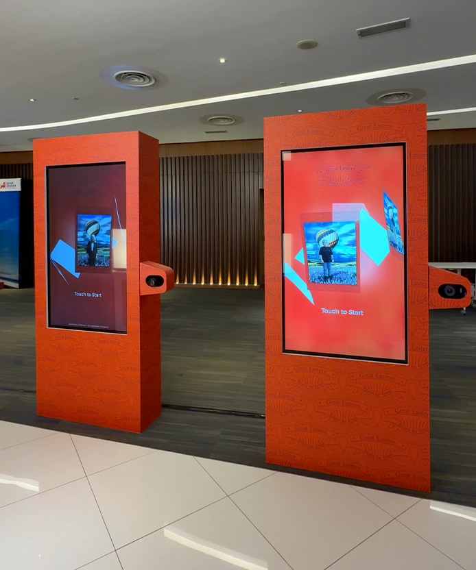 Pair of red Great Eastern interactive kiosks in an office lobby.
