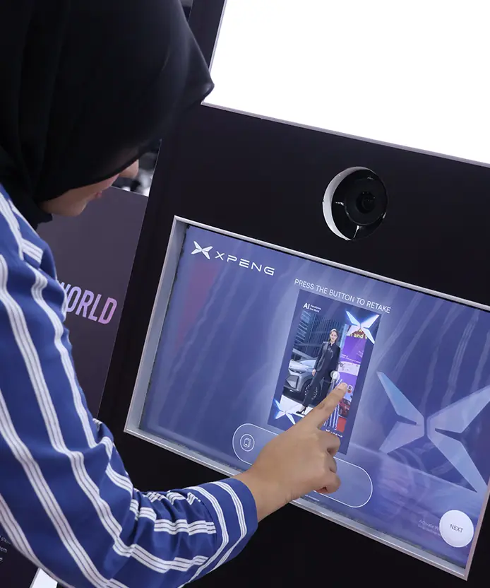 Close-up of a guest confirming her AI-generated portrait with an XPENG vehicle backdrop on the Instabox touchscreen
