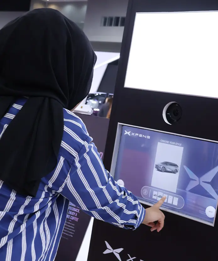 Guest selecting an XPENG vehicle type on the Instabox touchscreen before AI photo generation