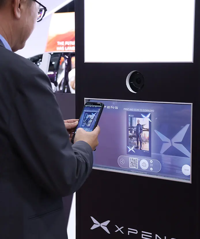 Guest scanning the QR code on the XPENG Instabox screen to download his AI-generated photo