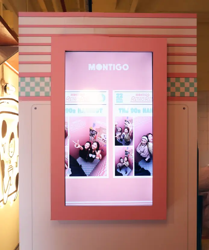 Montigo Retro Reel photobooth digital screen previewing The 90s Hangout newspaper photo strip