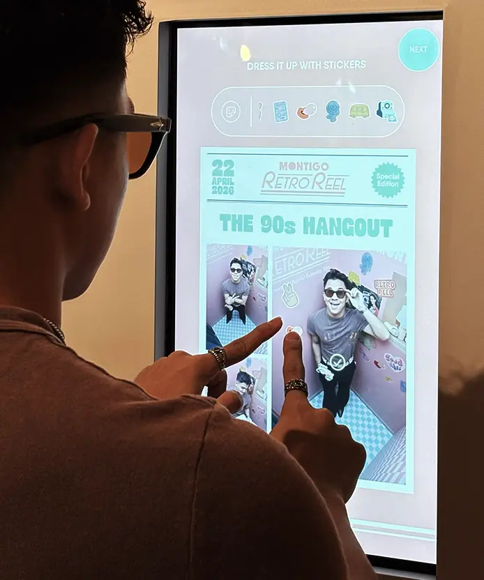 Guest customizing captured photo with retro stickers on the Montigo Retro Reel touchscreen