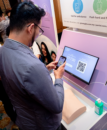 Participant scanning the QR code to enter details at the IHH CPR training booth, Malaysia