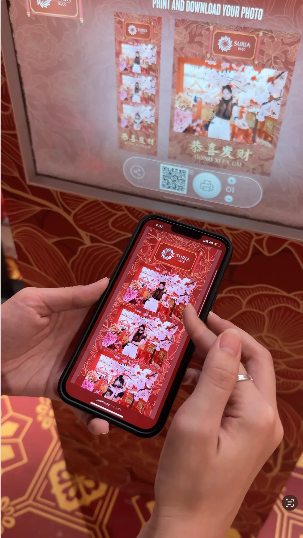 Visitor scanning the booth's QR code with a phone to download Suria KLCC Chinese New Year photos to her mobile gallery
