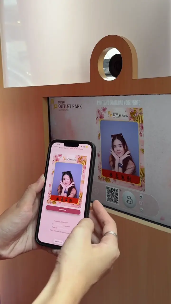 Visitor scanning the Mitsui Outlet Park photo booth's QR code to download her Chinese New Year photo to her phone