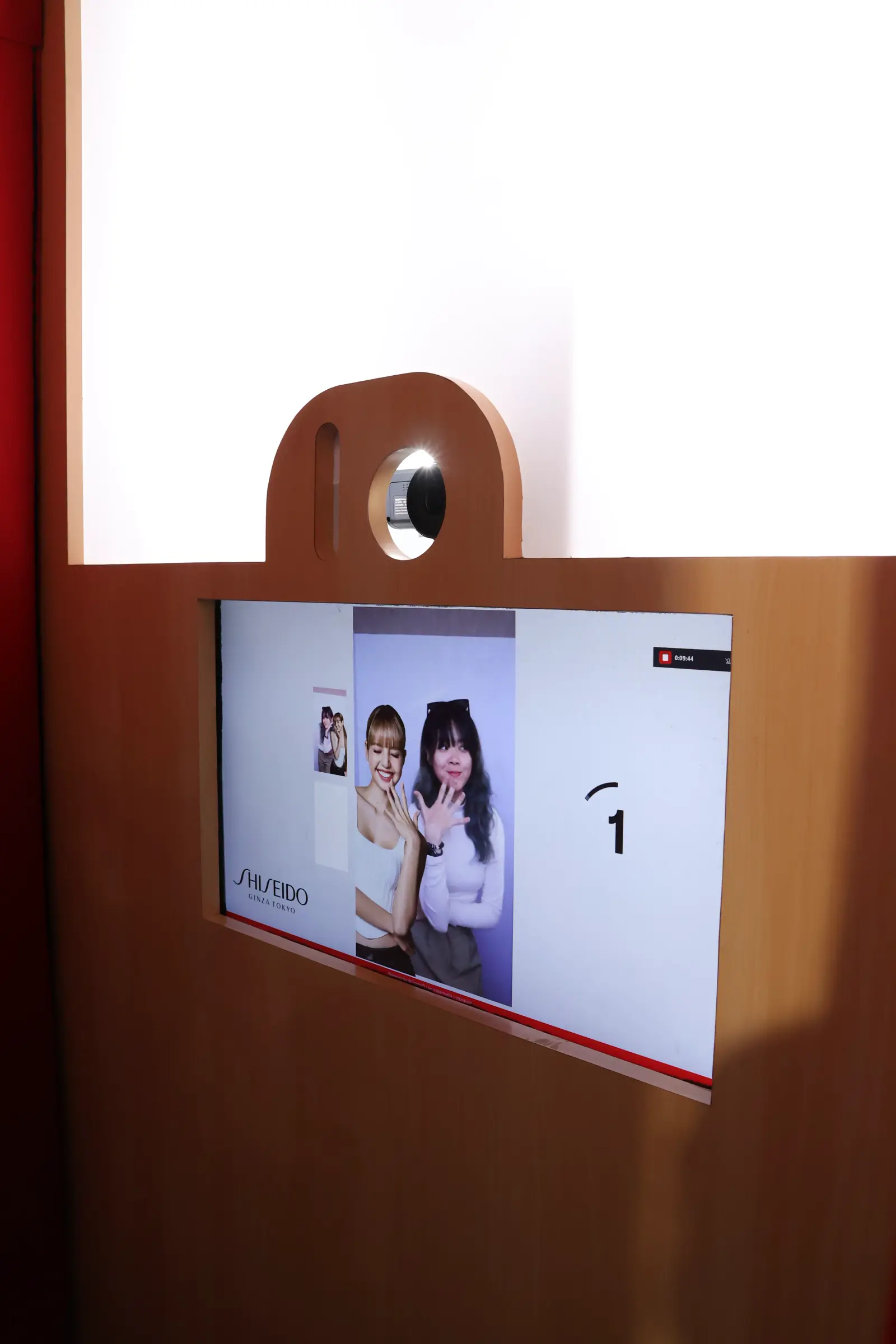 Shiseido photo booth screen previewing a snapshot of two visitors with the SHISEIDO logo and countdown timer