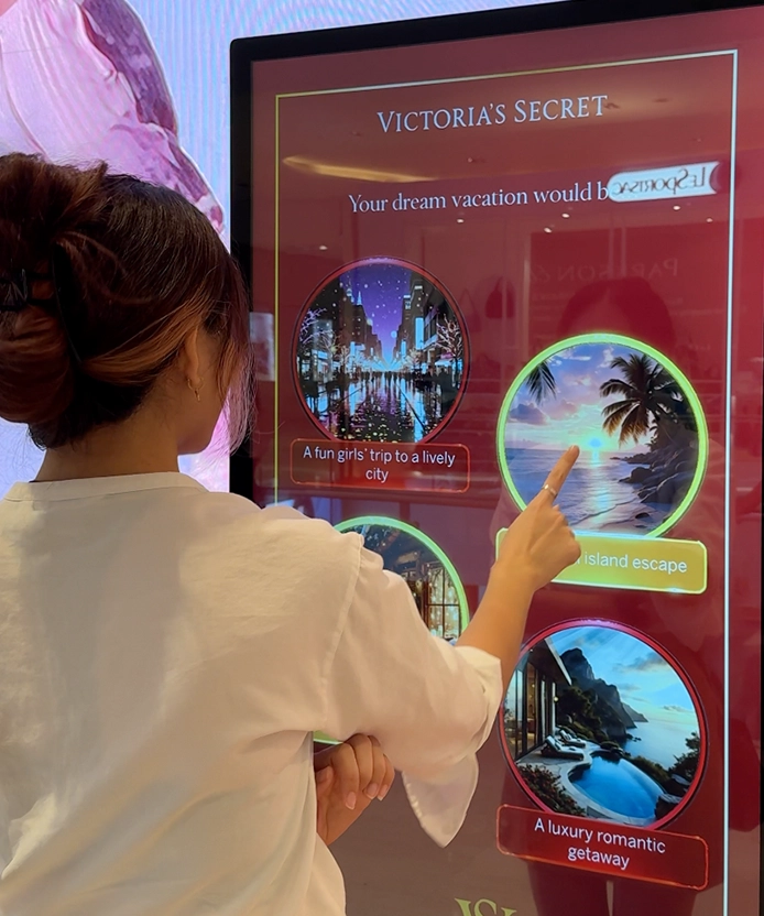 Woman tapping the 'island escape' option on Victoria's Secret's interactive scent-finder screen at Pavilion KL, Kuala Lumpur