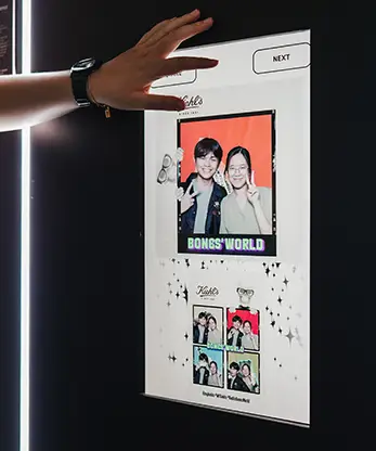 Kiehl's Bones' World Roadshow AI photo booth guest selecting photo on touchscreen interface Malaysia