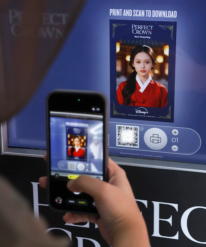 Visitor photographing the kiosk screen showing her AI hanbok portrait, with QR code and print options.