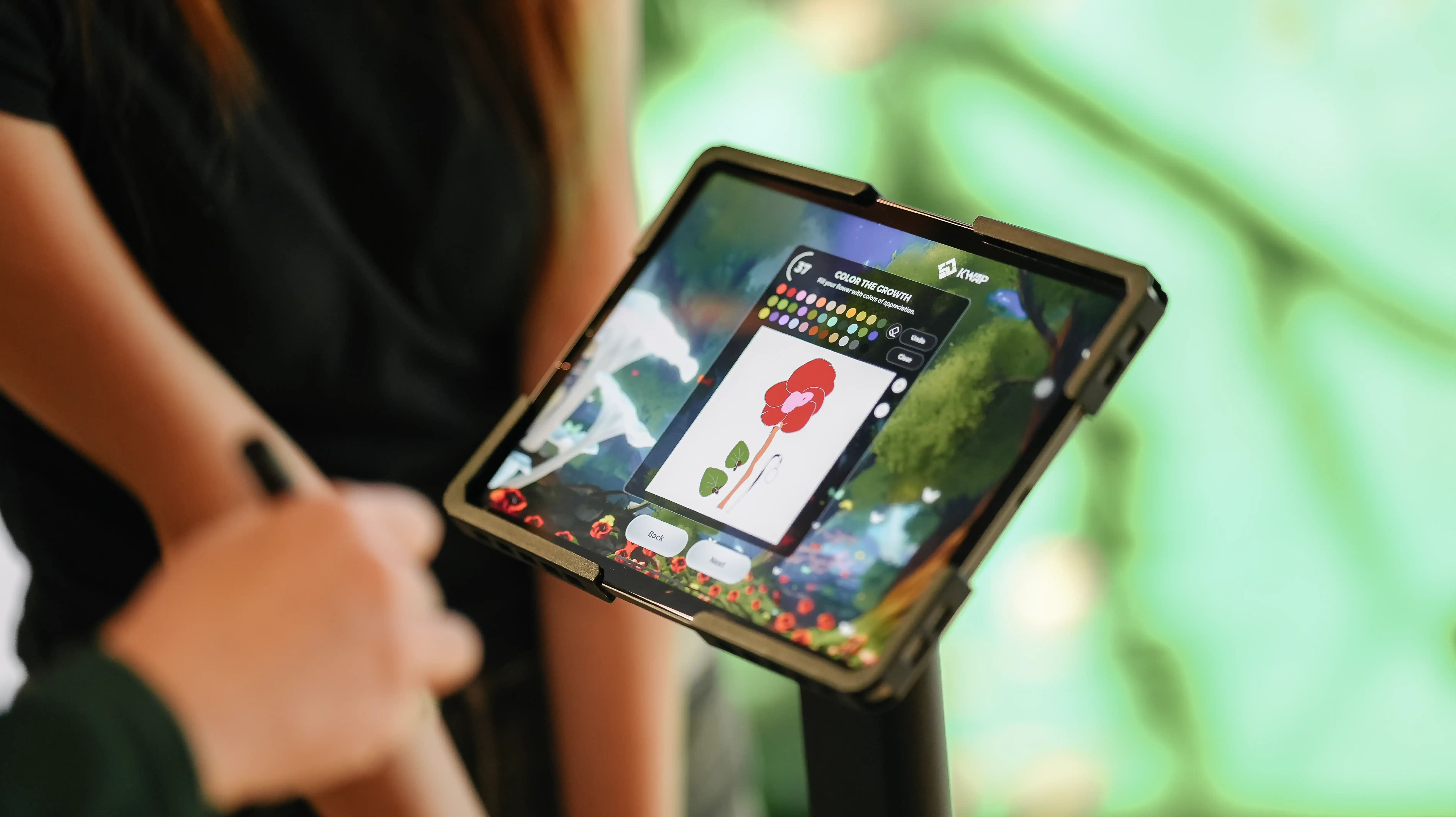 iPad station showing a digital garden coloring app as a guest personalises a flower design