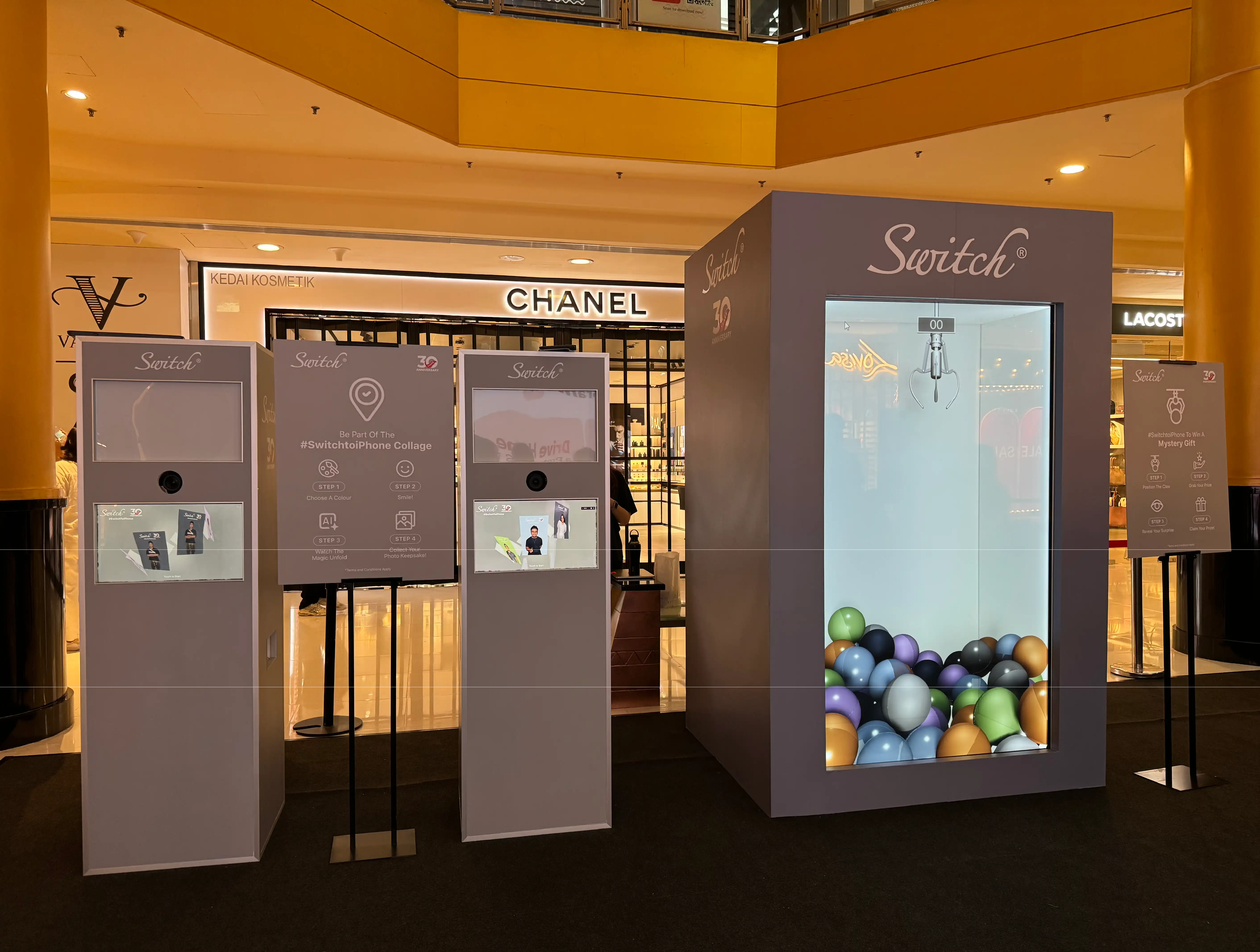 Switch branded digital claw machine filled with colourful balloons inside a shopping mall