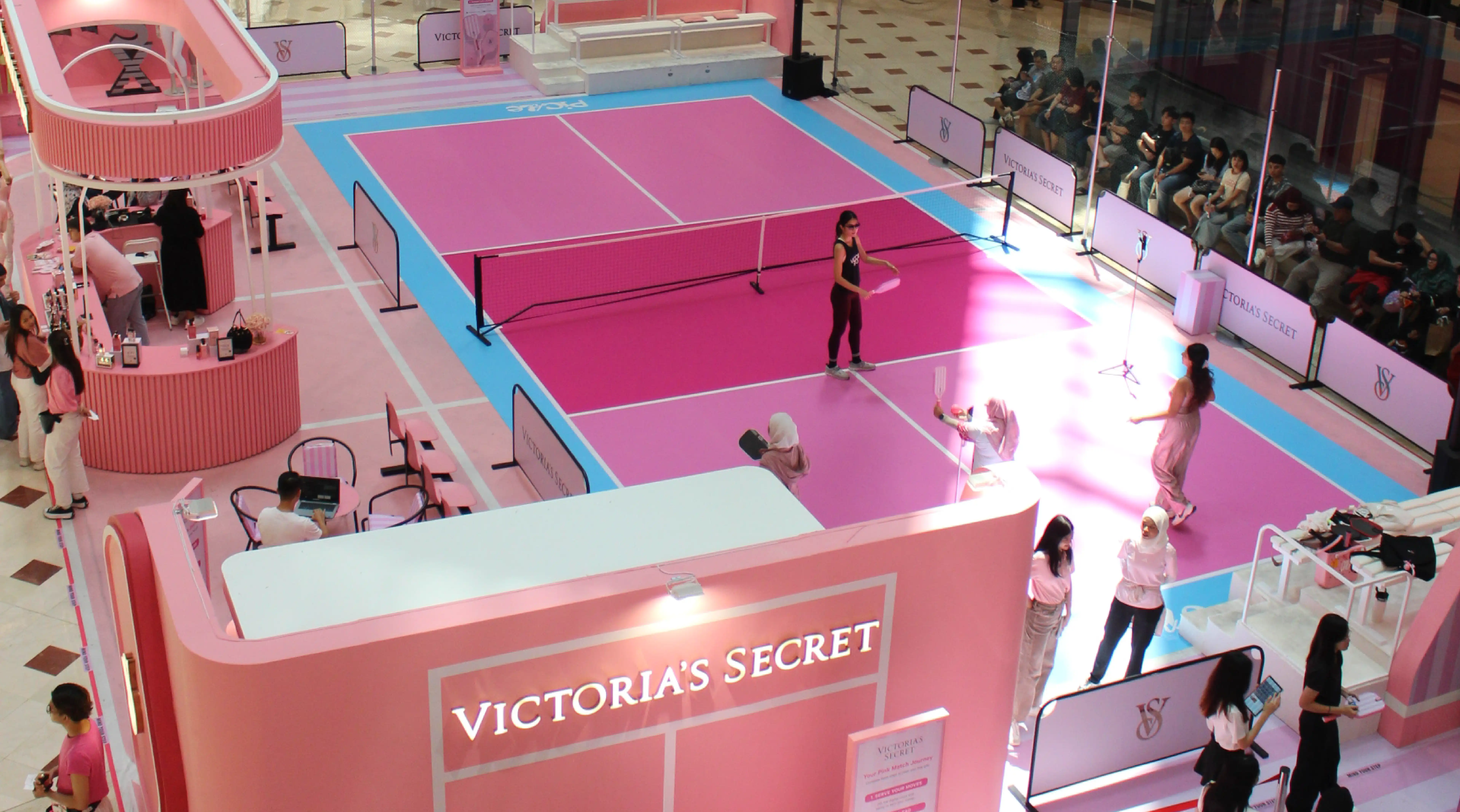 Victoria's Secret branded pink pickleball court activation with players inside a mall
